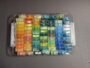 Close-up of 2.6mm mini fuse beads pre-sorted in a plastic storage organizer